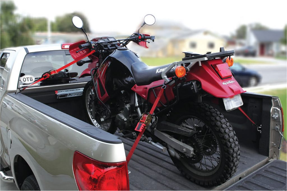 dirtbike in black and red colors secured by Strapinno retractable ratchet straps on a silver pickup truck