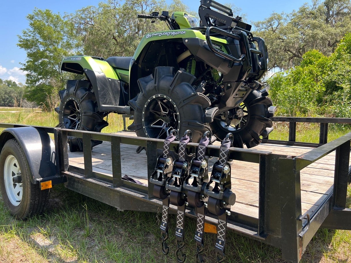 light green and black ATV attached to a truck bed with Strapinno retractable ratchet straps
