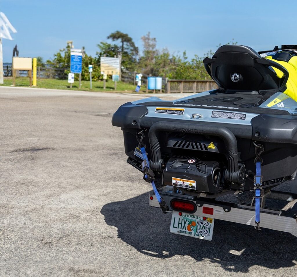 a jet ski in black and yellow colors secured using Strapinno's blue retractable ratchet straps
