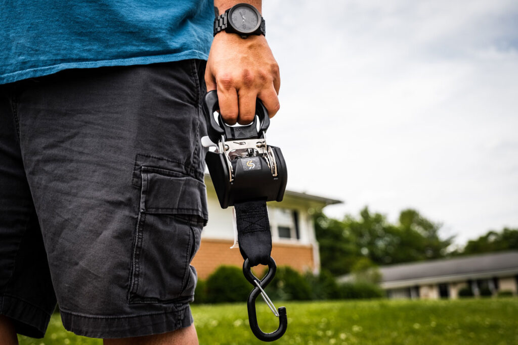 person holding Strapinno's dual lock retractable ratchet straps