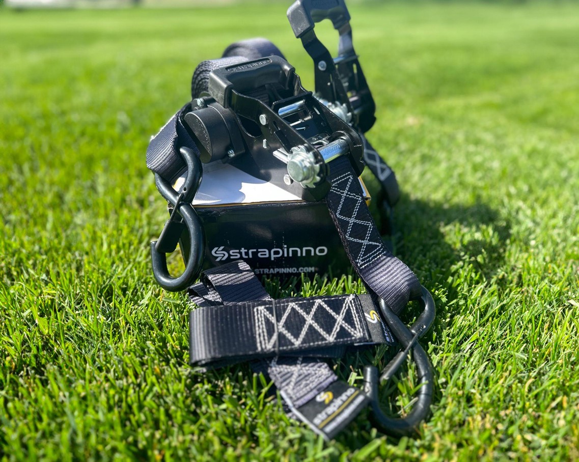 Strapinno retractable ratchet straps in black on the grass on a sunny day