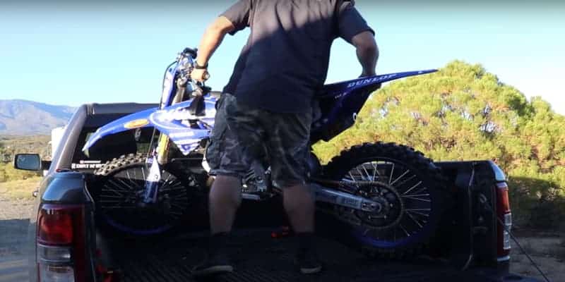 Load the dirt bike on the truck bed and park diagonally.