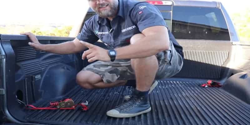 One self-retracting ratchet strap at the end of the truck bed, and the other one at the front.