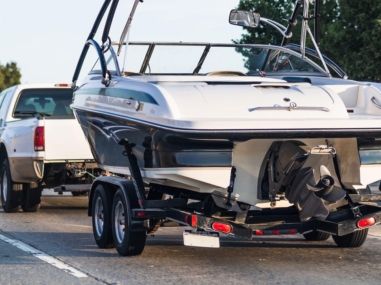 white boat on a trailer secured using retractable tie-down straps