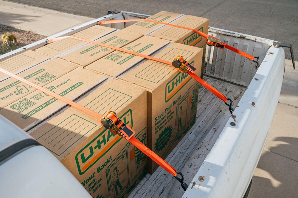 u-haul boxes on a white pick-up truck secured by Strapinno retractable ratchet straps