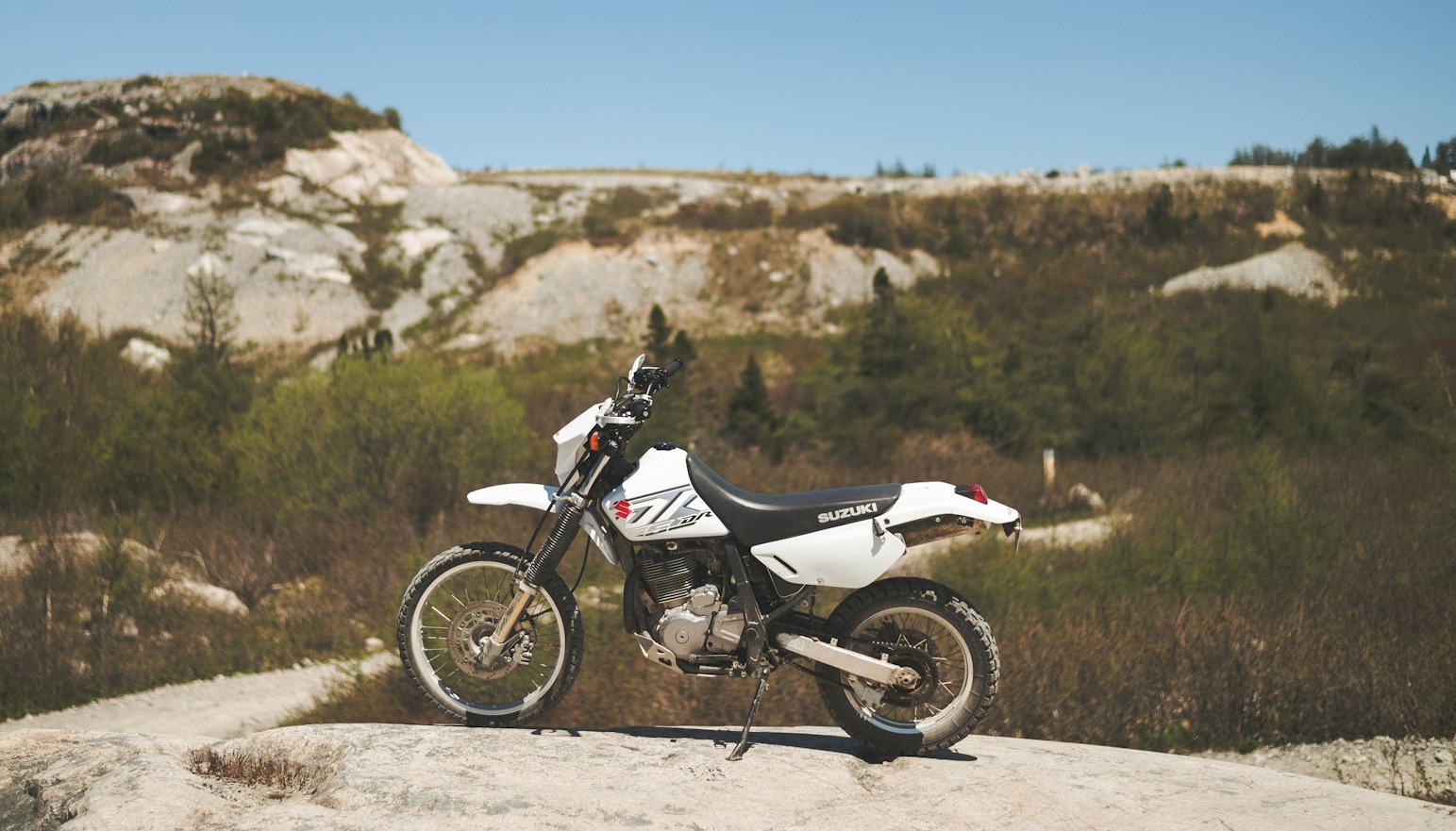 white and black dirt bike on dirt road during daytime